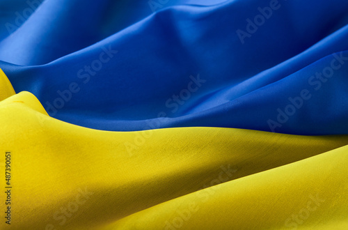 Fabric textured flag of Ukraine, UA. Blue and yellow colors. Close up shot, selective focus, background photo