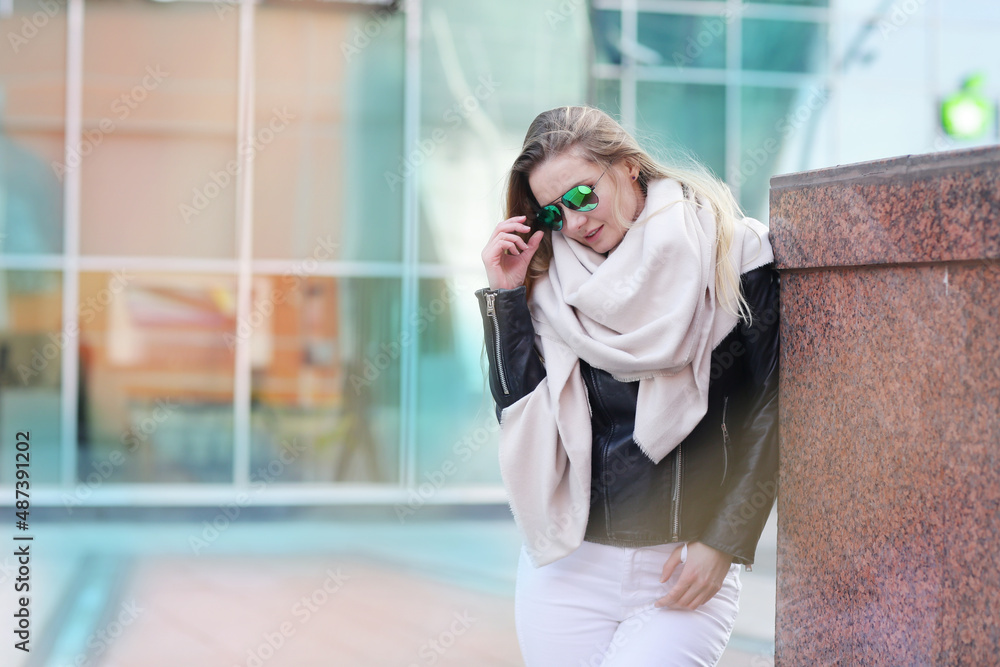 Fototapeta premium young blond slavic woman with long hair in black leather jacket closeup street portrait with glasses on shaping mall background