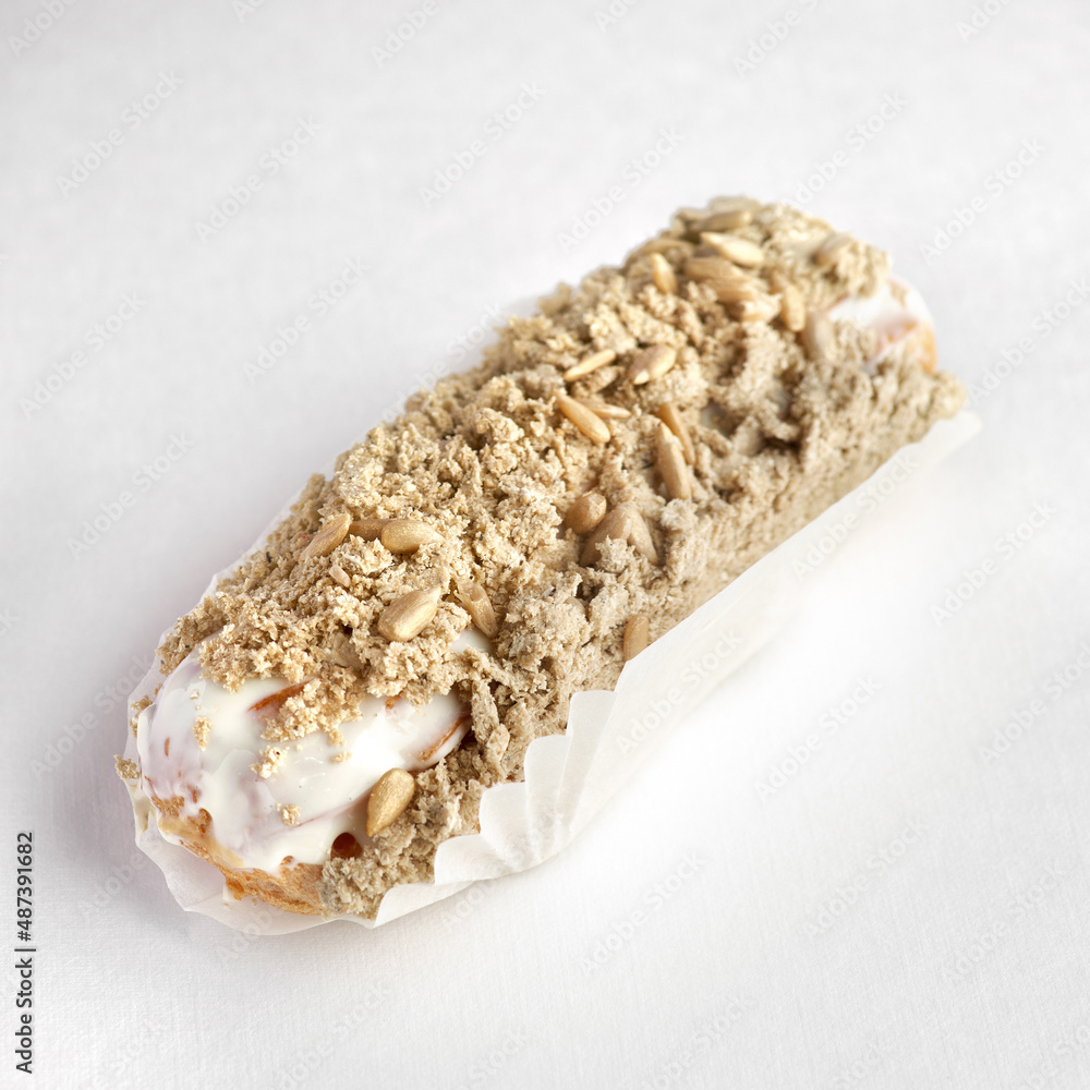 Traditional French dessert. eclair with custard and glaze with halva on a white background.