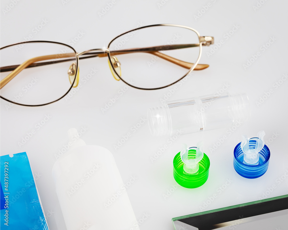Contact lens kit with lenses, container, glasses and eye drops on a