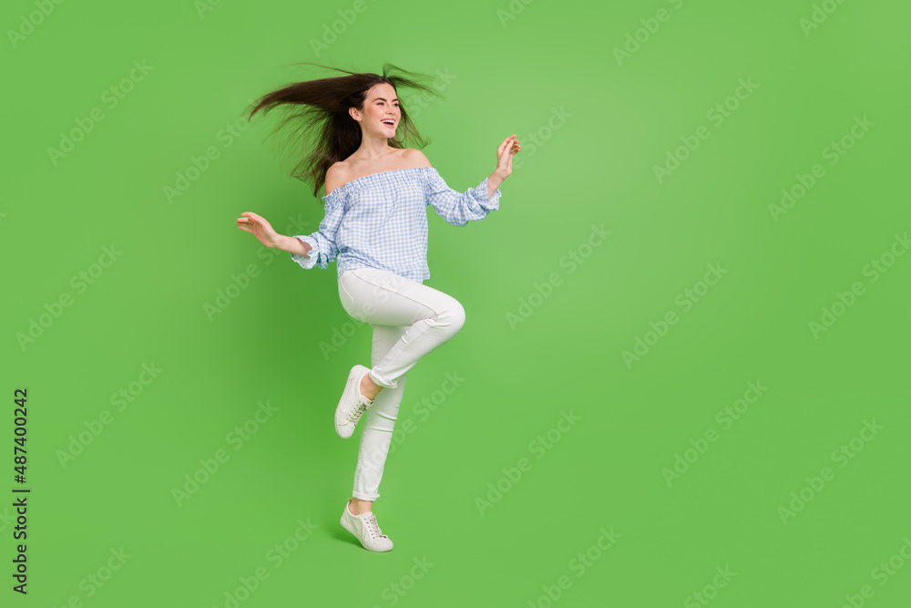 Full size photo of cute sweet girl with flying hair have fun dancing spend free weekend time isolated on green color background