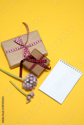 on a yellow background lilac primrose flowers, notepad, gift box. card, congratulations on March 8