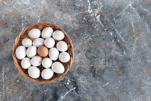 White and brown chicken eggs in a wooden basket.Farm product Easter concept.