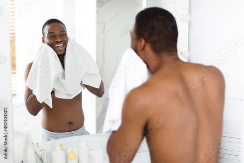 Morning Routine. Happy Shirtless Black Young Guy Wiping Face With Towel