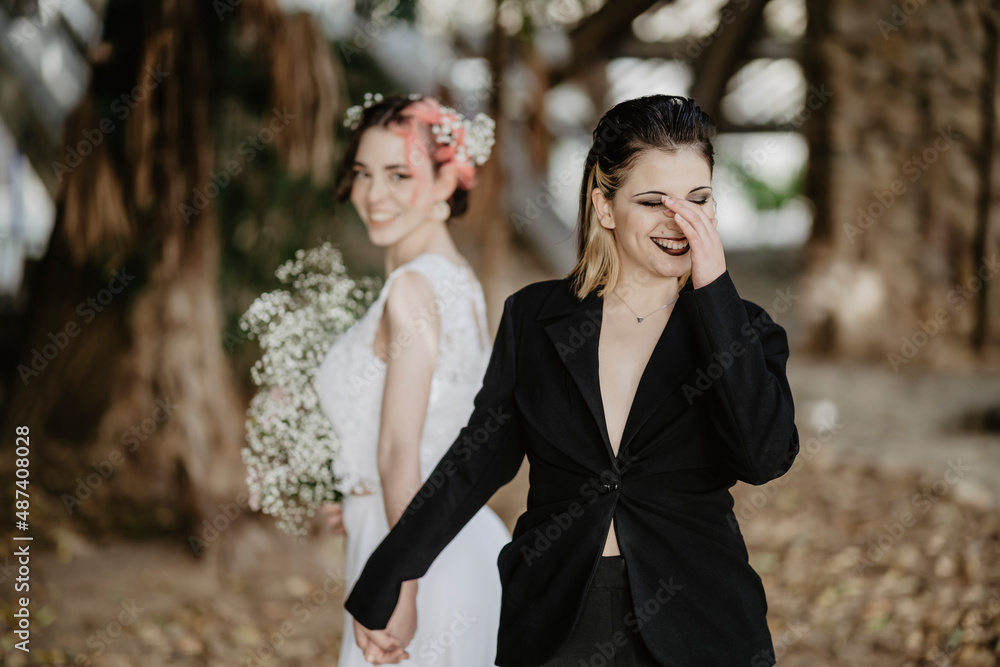 Happy brides laughing during wedding in forest Happy brides laughing during wedding in forest