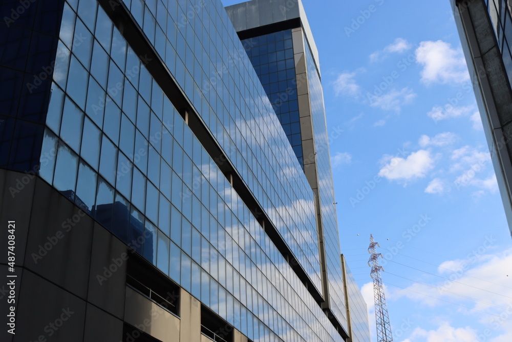 Genova, Italy - January 29, 2022: Beautiful modern high-rise buildings against the sky. 3d illustration on the theme of business success and technology. clouds reflection on the mirror.