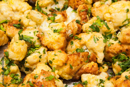 Fried cauliflower sprinkled with chopped green onions. Brassica oleracea.