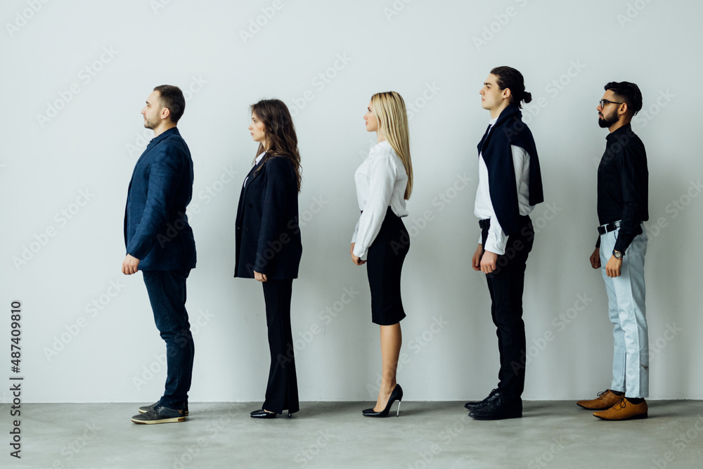 Obraz premium Full length side view of business people walking in queue against white background