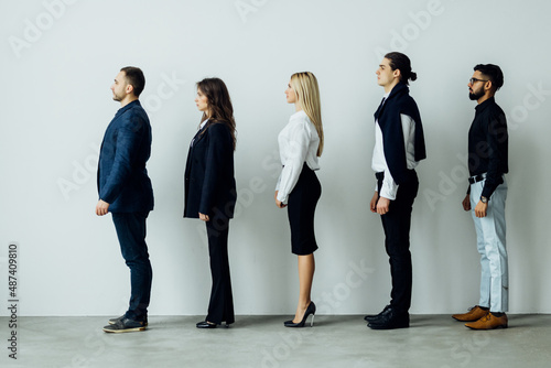 Full length side view of business people walking in queue against white background