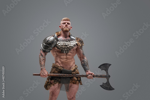 Fierce scandinavian soldier with naked torso and huge axe