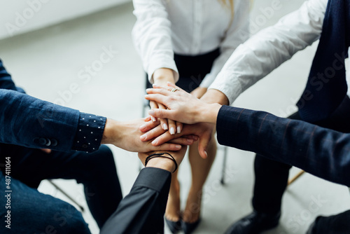 Coworkers giving high-five in meeting room at creative modern office