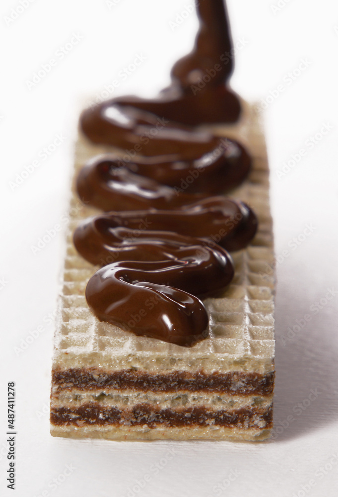 Pouring melted chocolate cream on chocolate cookie. Pouring melted chocolate cream on chocolate cookie.
