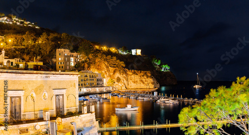 Panorama of the bay of Lacco Ameno in the night in summer, with the promontory and the tower of Monte Vico. Ischia island. Italy.