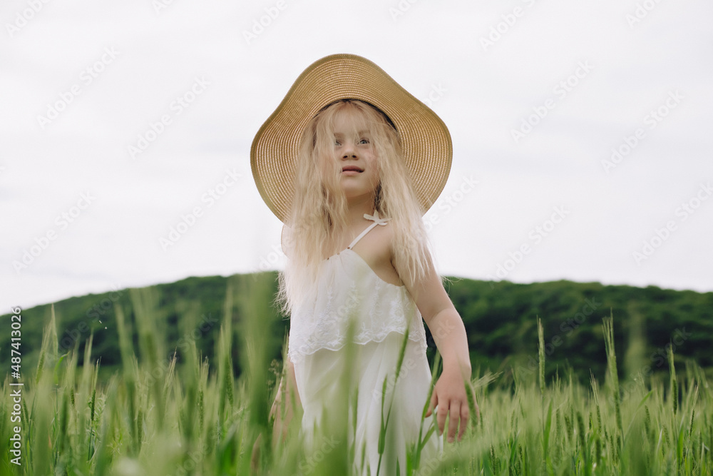 Obraz premium Adorable little girl playing in the wheat field on a warm summer day
