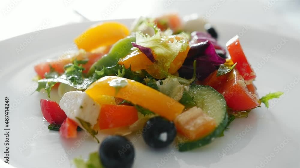 Girl puts vegetable salad on a white plate Girl puts vegetable salad on a white plate