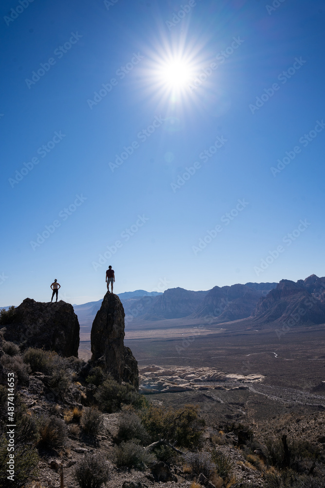 Two figures standing on Rocks overlooking Red Rock