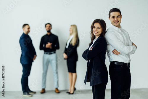 Happy young business person in modern office in front of colleagues