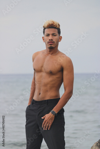 Portrait of cool young african man dancing at the beach on summer day photo