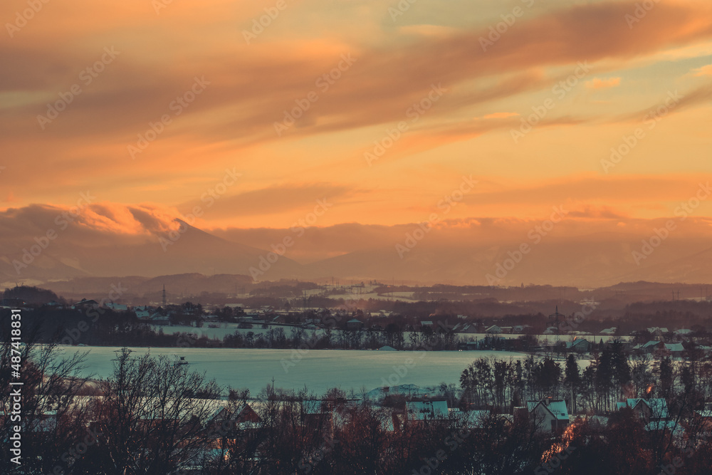 colorful sunset clouds over the countryside in czech republic with snow and mountains in the background on a winter day colorful sunset clouds over the countryside in czech republic with snow and mountains in the background on a winter day