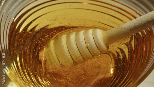 Honey dipper in glass bowl photo