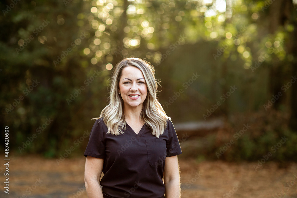 A medical professional with black scrubs with long hair outside in a natural background with copy space A medical professional with black scrubs with long hair outside in a natural background with copy space