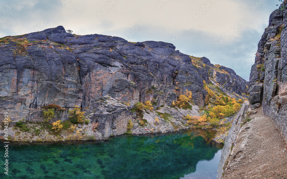 Emerald lake in the Khibiny mountains. Lake with emerald water with rocky shores. Emerald lake in the Khibiny mountains. Lake with emerald water with rocky shores.
