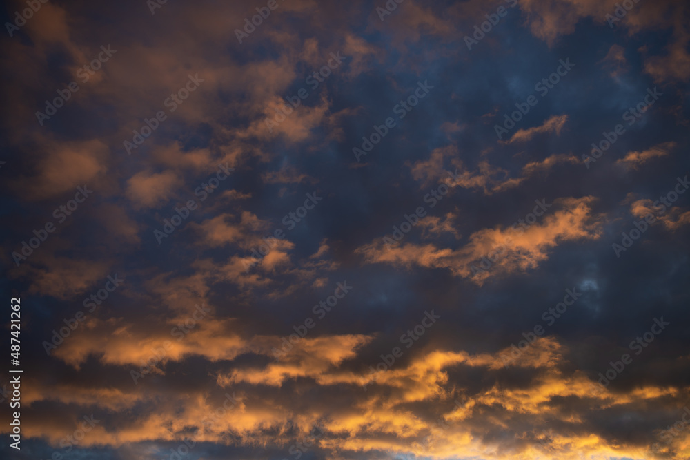 Dense dramatic painted clouds at sunset of the day against a blue sky