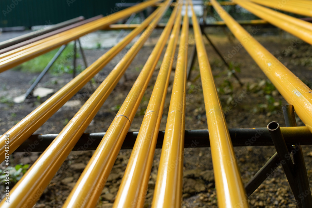 Yellow pipes. Gas pipes lie in row. Preparation of equipment replacement. Yellow pipes. Gas pipes lie in row. Preparation of equipment replacement.