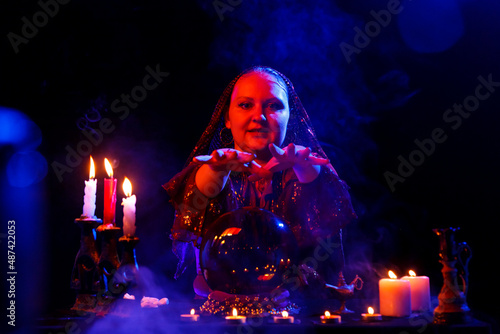 a young fortune-teller in the salon reads fortunes on a magic crystal.