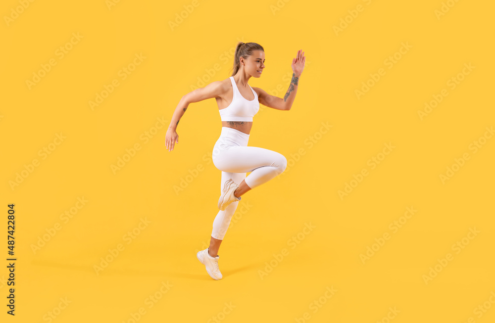 active fitness girl runner running on yellow background