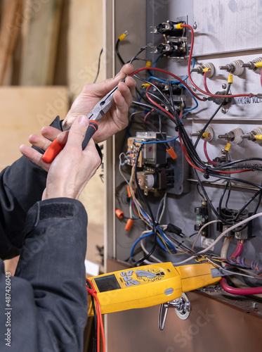 Hot air furnace service with technician hand holding a meter photo