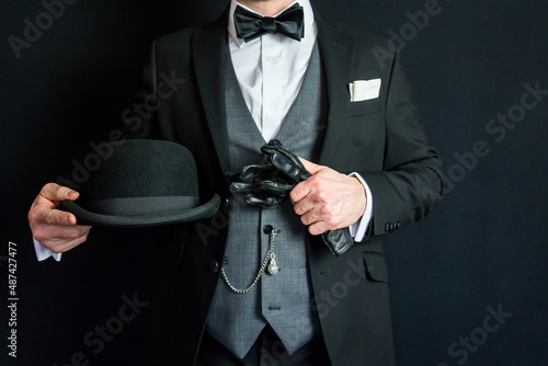 Cuadro en lienzo Portrait of Man in Dark Suit Holding Leather Gloves and Bowler Hat