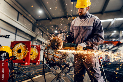 Quadro su tela A metal and iron factory worker processing metal construction with grinder