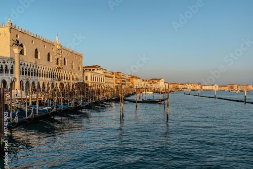 Venice,Italy.Embankment and famous Doges Palace on sunny day,canal and gondolas.Venetian city lifestyle.Architecture and landmark of Venezia.Popular tourist destination.Water transport,old houses