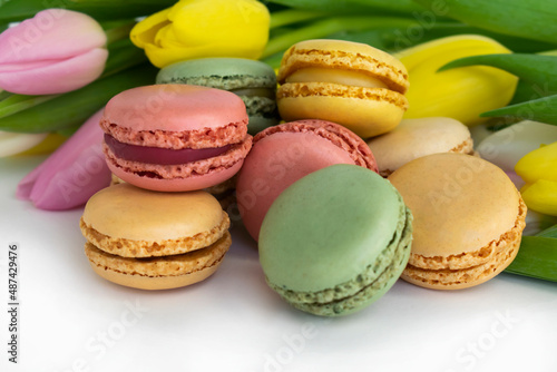 colorful macarons and tulips isolated over white bakground
