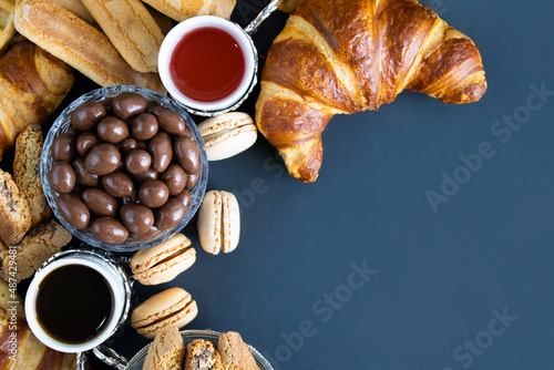 coffee and breakfast treats isolated over dark background with copyright space