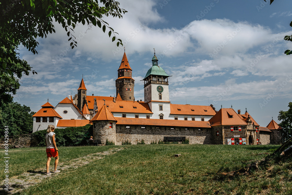 Girl walking to Bouzov Castle,Czech Republic.Romantic fairytale chateau with eight-storey watchtower built in 14th century.National cultural monument,popular tourist place.Picturesque location Girl walking to Bouzov Castle,Czech Republic.Romantic fairytale chateau with eight-storey watchtower built in 14th century.National cultural monument,popular tourist place.Picturesque location