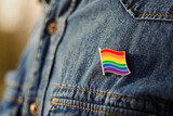 Close up of LGBT pin in the form of a flag is pinned on blue jeans jacket. LGBT rights concept.