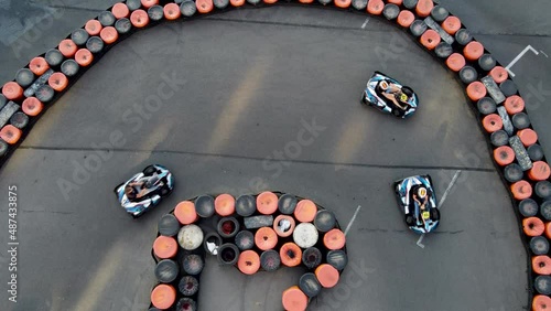 Drone top-down view of curvy turn  on a karting track with carts in high speed turns.