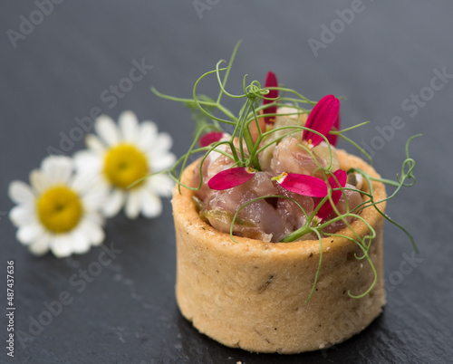 Modernes Fingerfood aus Matjes / Kanapees / Amuse bouche mit essbaren Blüten dekoriert photo