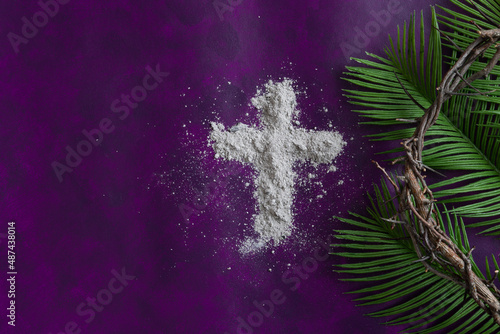 cross of ashes with border of palm fronds and crown of thorns on a dark purple background