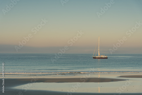 Sailing boat on the beach of Los Lances with the soft lights of the sunrise, Tarifa, Cadiz, Andalusia, Spain photo