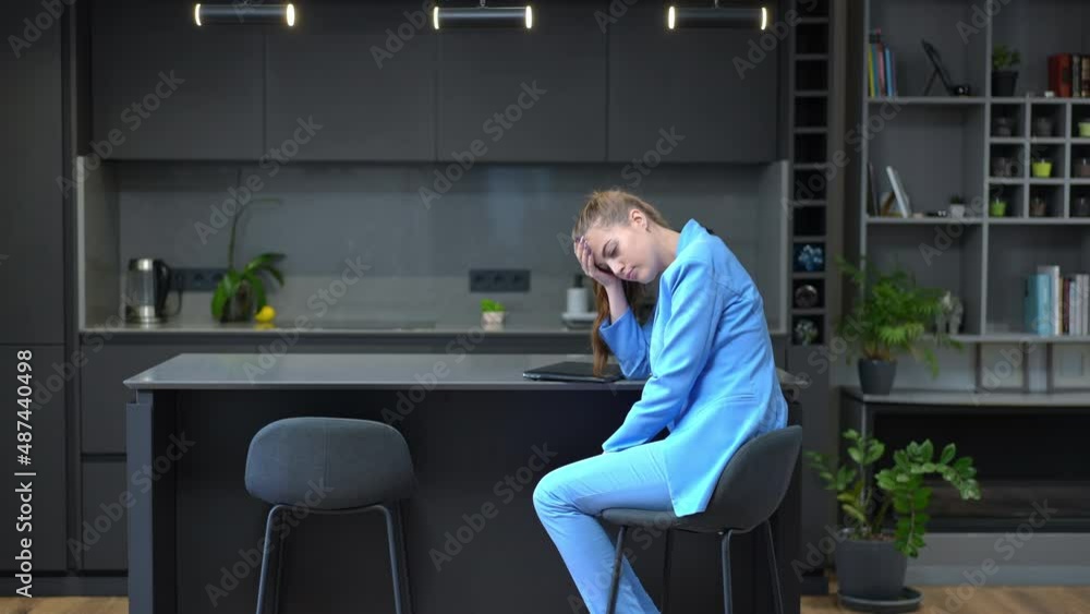 Wide shot side view beautiful slim young woman closing laptop sighing working online in home office. Exhausted tired Caucasian freelancer in elegant suit indoors in kitchen. Remote working concept Wide shot side view beautiful slim young woman closing laptop sighing working online in home office. Exhausted tired Caucasian freelancer in elegant suit indoors in kitchen. Remote working concept