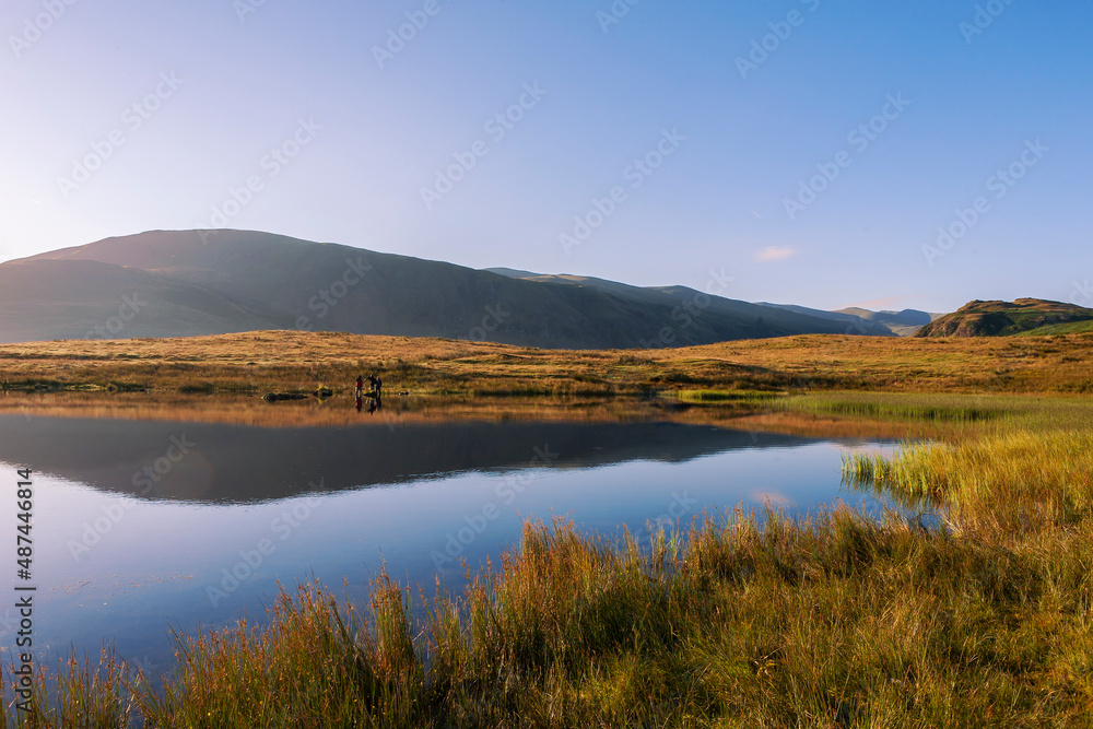 Obraz premium A peaceful early Summer's morning at Tewet Tarn and St. John's-in-the-Vale, Lake District, Cumbria, UK