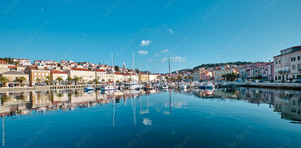 view of the port of mali losinj with the boat and reflection on the sea surface