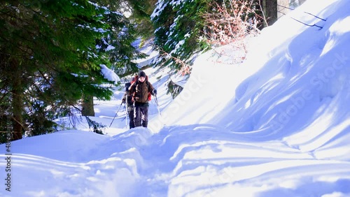 Backpackers go to the top of the hiil early in the morning. Beautiful sunrise at mountains. Winter snowy forest. Shiny winter day. photo