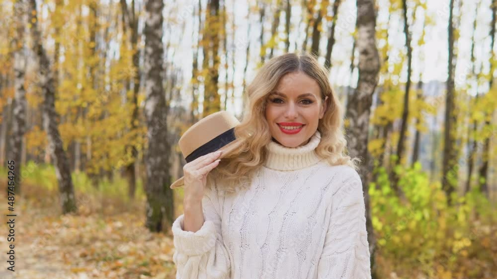 Portrait of smiling happy cheerful woman with brown hat in autumn park Portrait of smiling happy cheerful woman with brown hat in autumn park