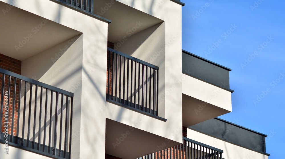 Fototapeta premium Abstract architecture, fragment of modern urban geometry,. Modern apartment building on a sunny day with a blue sky,. European residential apartment buildings.