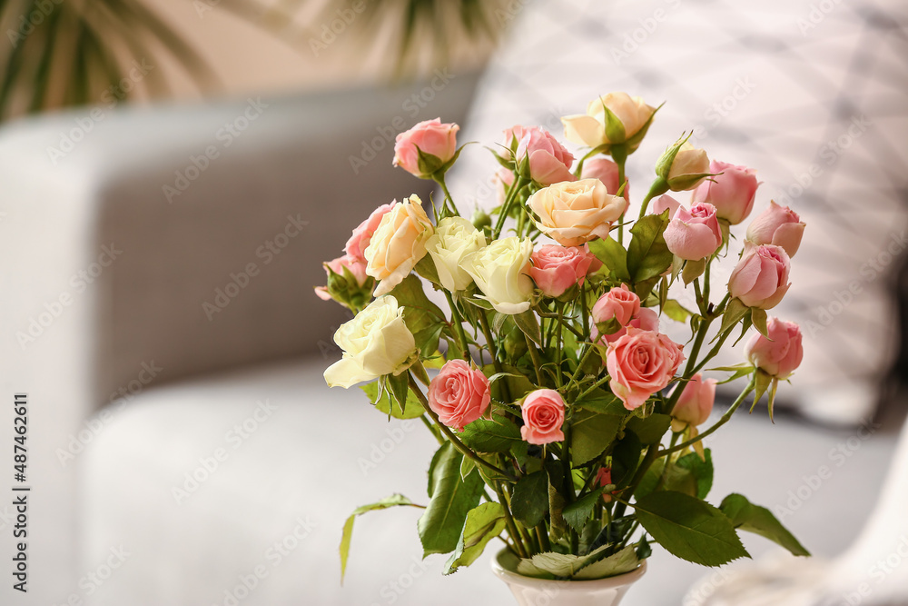 Vase with small beautiful roses in room