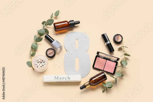 Composition with decorative cosmetics, figure 8 and eucalyptus branches for International Women's Day celebration on color background
